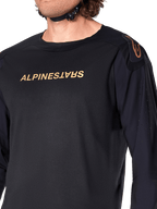 Alpinestars A-Aria Polartec Switch Jersey met lange mouwen, zwart, voorzien van bronskleurige Alpinestars-branding op de borst en schouder, laserperforaties op de mouwen voor ventilatie, technische performance MTB-kleding