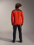 Alpinestars A-Dura Insert Astar Jersey met lange mouwen in Spicy Orange, achteraanzicht met antracietgrijs schouderpaneel, gedragen met zwarte Alpinestars-broek en zwarte schoenen, professionele studiofoto van MTB-prestatiekleding
