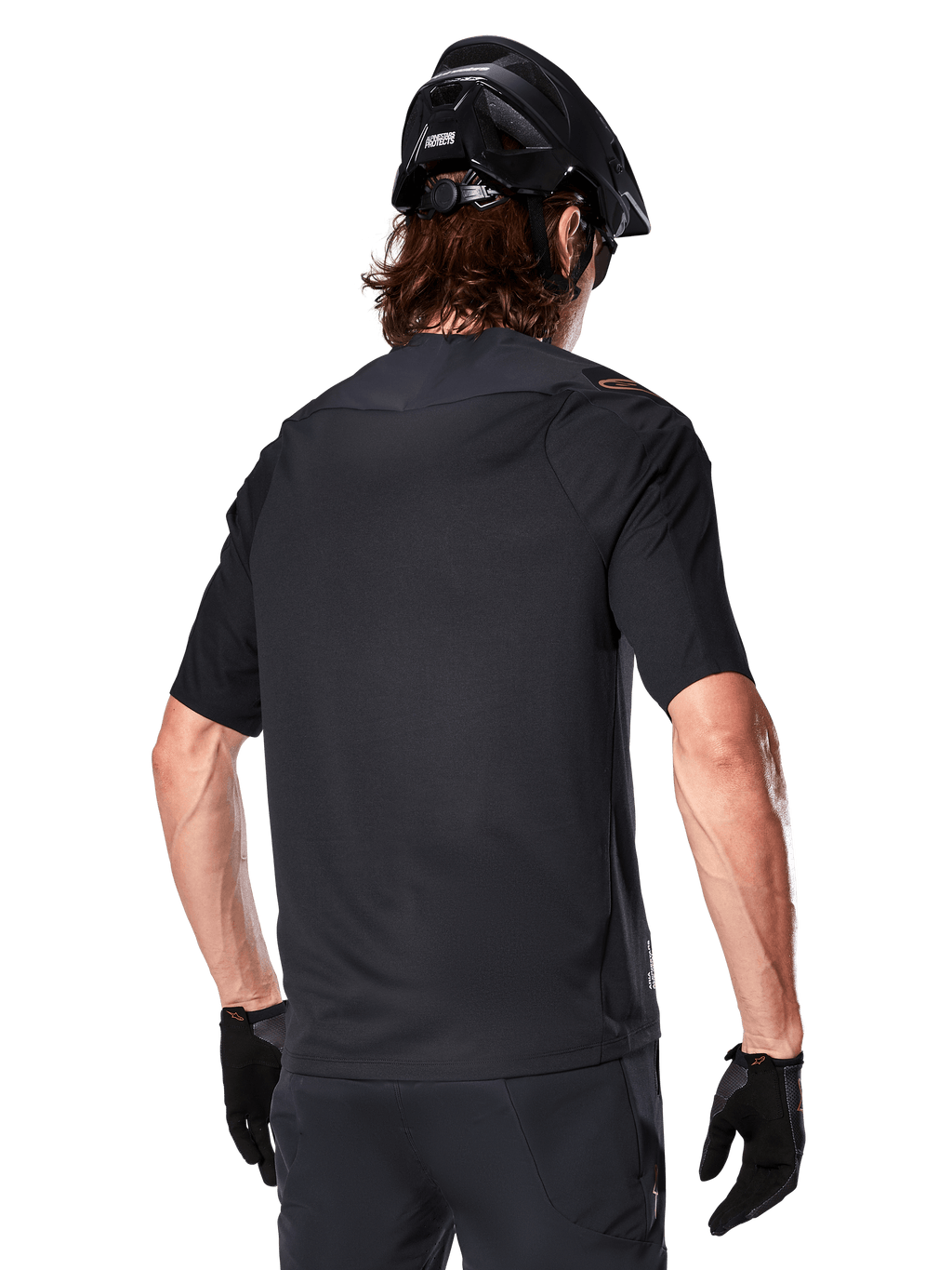 Alpinestars A-Aria Polartec Switch jersey met korte mouwen, zwart, achteraanzicht van een rijder met een zwarte mountainbikehelm, bijpassende zwarte short en handschoenen, performance kleding voor mountainbiken