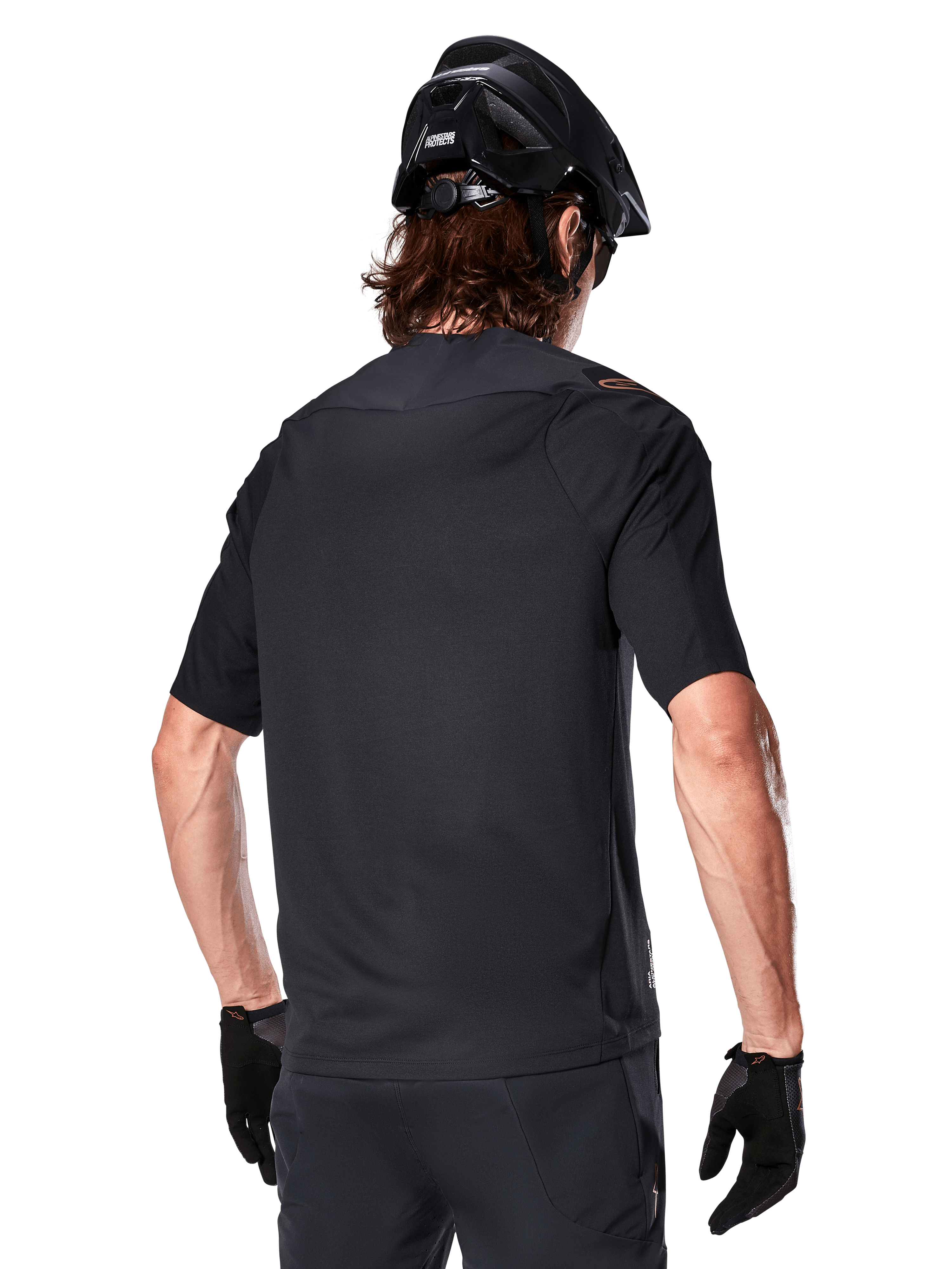 Alpinestars A-Aria Polartec Switch jersey met korte mouwen, zwart, achteraanzicht van een rijder met een zwarte mountainbikehelm, bijpassende zwarte short en handschoenen, performance kleding voor mountainbiken