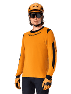 Alpinestars A-Dura Dri Wool Jersey - Long Sleeve, MTB Mountain Biking Jersey, Dark Gold and Black, featuring moisture-wicking merino wool blend and mesh panels, rider wearing matching helmet, sunglasses, and gloves