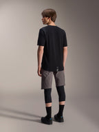 Alpinestars A-Dura Dri Wool Jersey met korte mouwen en A-Dura Elite Shorts, zwarte en donkergrijze mountainbikekleding, gedragen met zwarte kniebeschermers en sokken, achteraanzicht van fietskleding voor off-road prestaties
