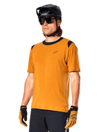 Alpinestars A-Dura Dri Wool Jersey - Short Sleeve, MTB cycling jersey, Dark Gold with black accents, short-sleeve technical wool blend shirt with black shoulder panels, worn with black mountain bike helmet and matching gloves