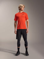 Alpinestars A-Aria Astar Jersey met korte mouwen, Spicy Orange, gedragen door model met zwarte mountainbike shorts en kniebeschermers, lichtgewicht en ademende performance fietskleding voor MTB