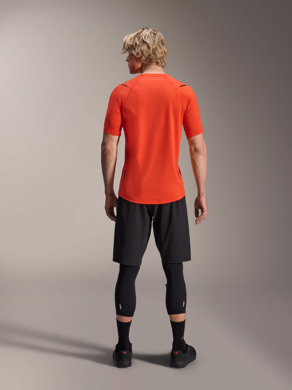 Alpinestars A-Aria Astar Jersey, MTB-jersey met korte mouwen, Spicy Orange, achteraanzicht met prestatiepasvorm en verlengde achterzijde, gecombineerd met zwarte fietsshort en leggings