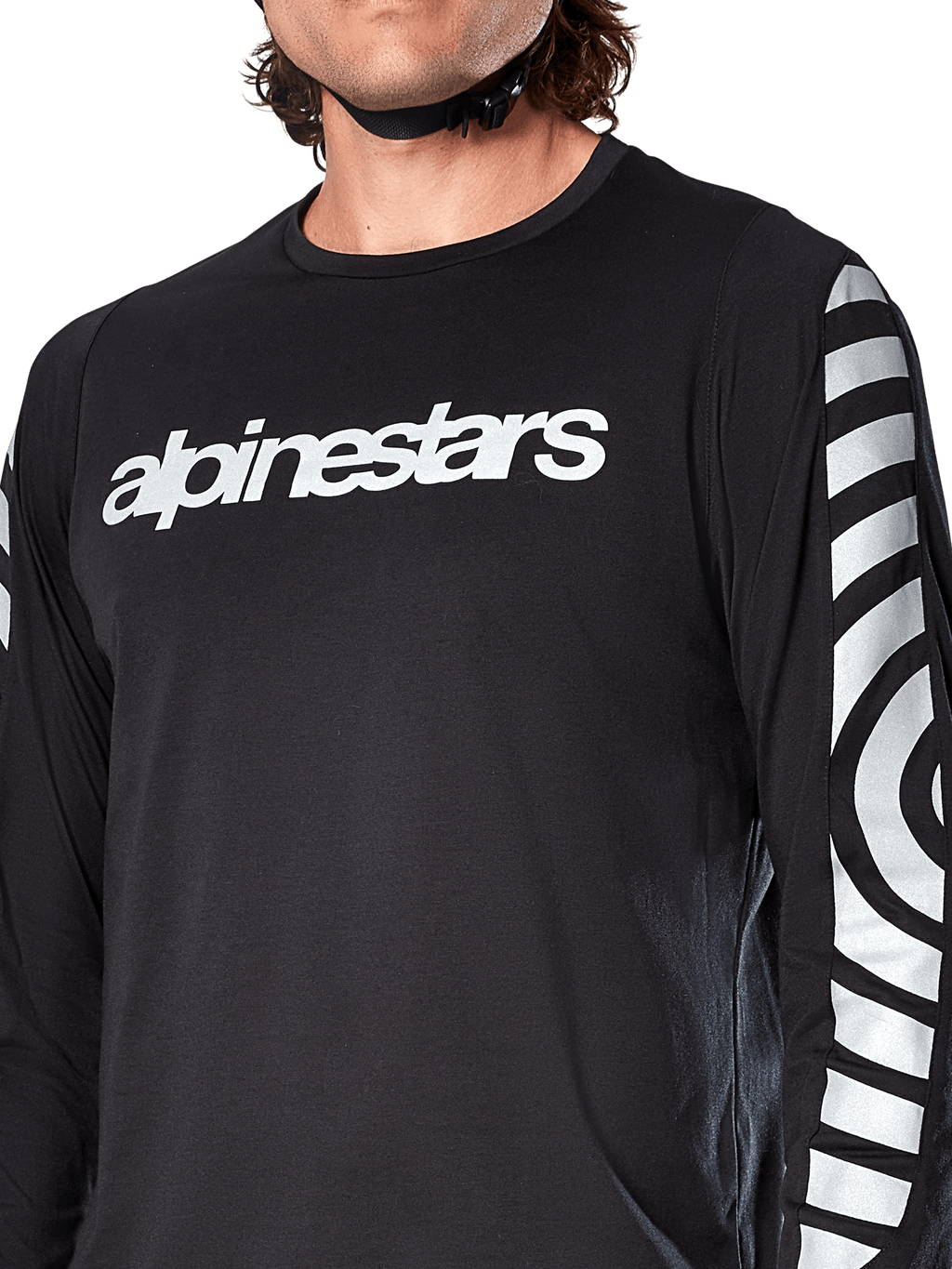 Alpinestars A-Dura Dri Oscar jersey met lange mouwen, Black Reflective, close-up met wit Alpinestars-logo op de borst en reflecterende cirkelvormige graphics op de mouwen, technische fietskleding voor mountainbiken