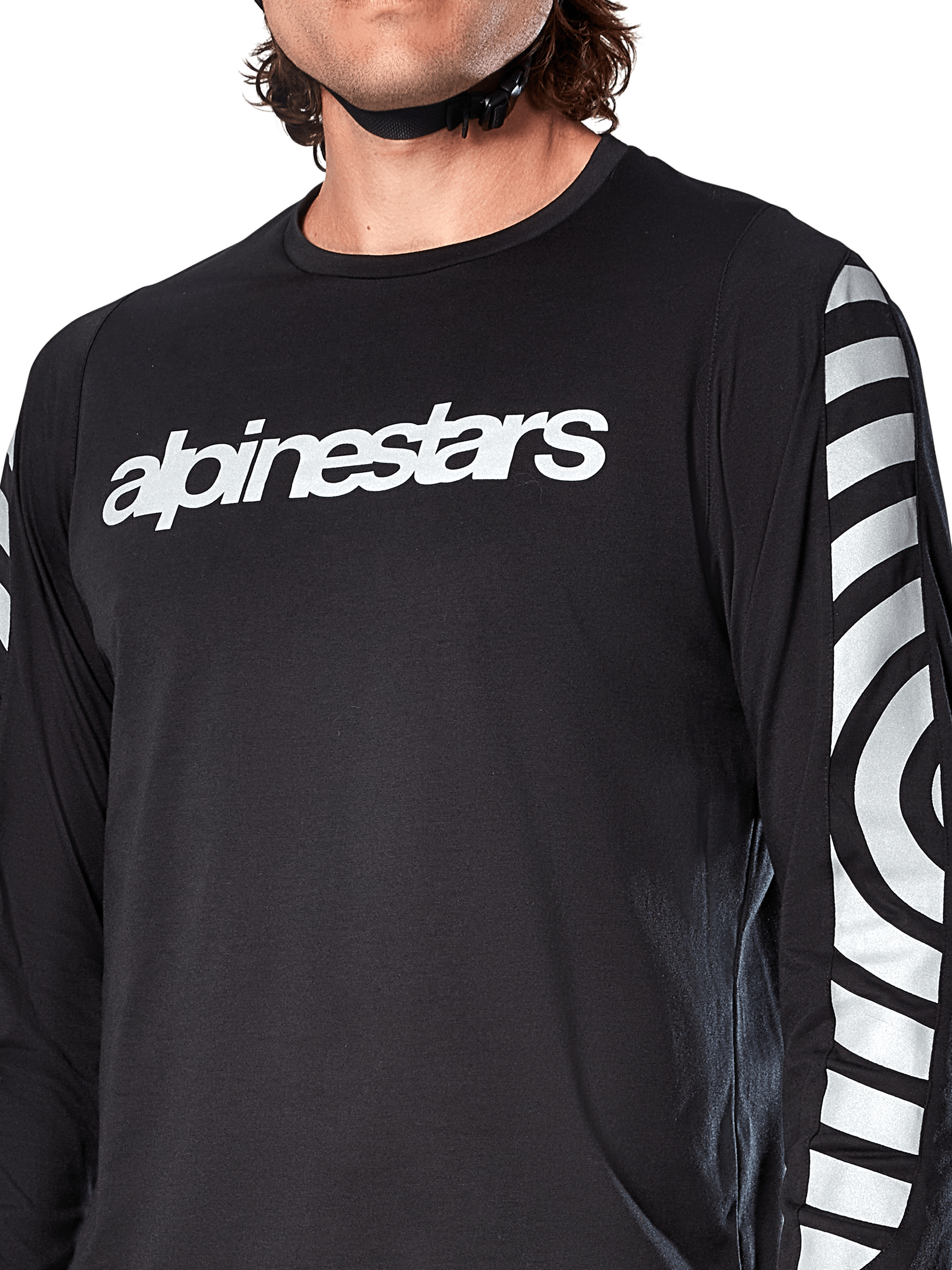 Alpinestars A-Dura Dri Oscar jersey met lange mouwen, Black Reflective, close-up met wit Alpinestars-logo op de borst en reflecterende cirkelvormige graphics op de mouwen, technische fietskleding voor mountainbiken