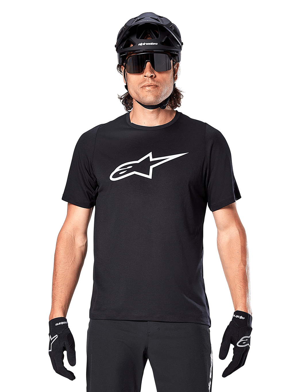Alpinestars A-Dura Dri Oscar Jersey met korte mouwen, Black Reflective, gedragen met zwarte MTB-helm, zonnebril en handschoenen, voorzien van een opvallend wit logo op de borst, technische kleding voor mountainbiken