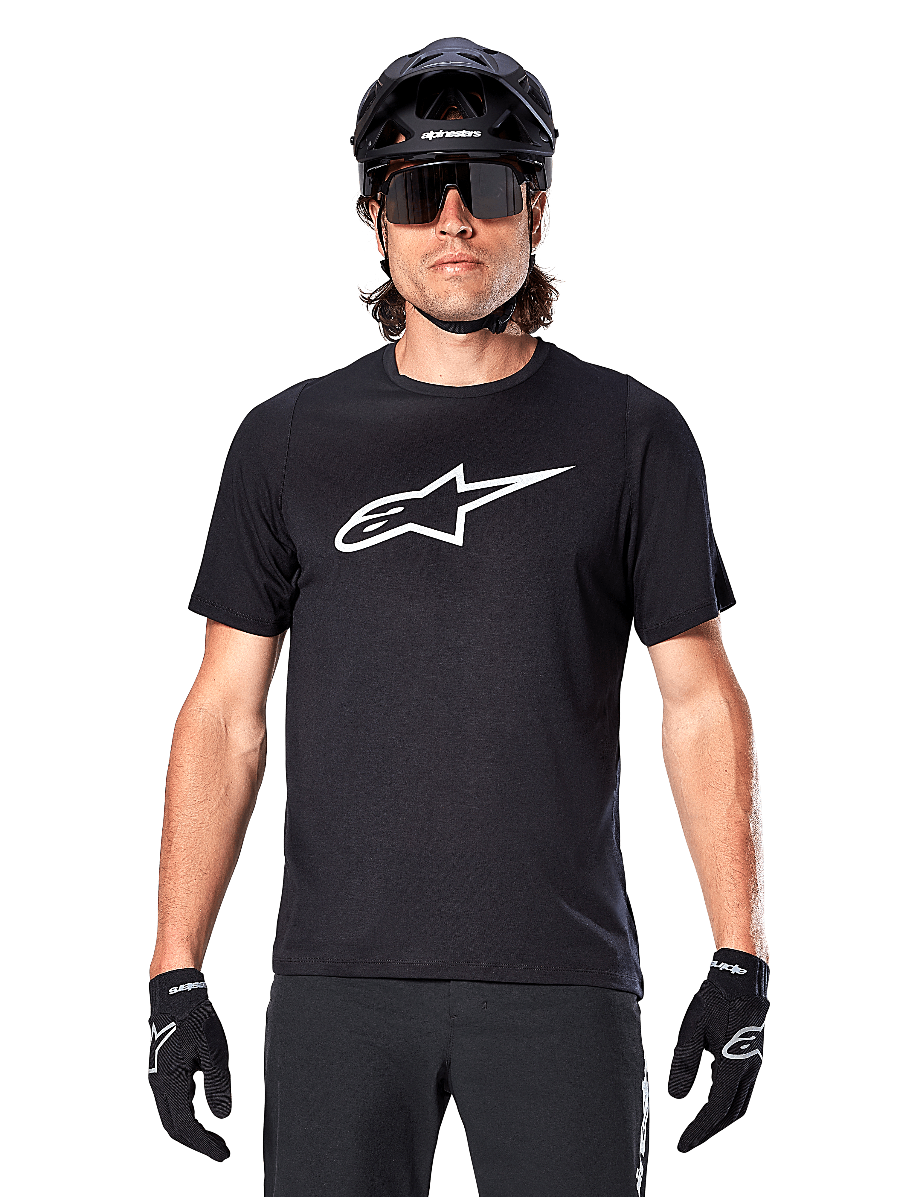 Alpinestars A-Dura Dri Oscar Jersey met korte mouwen, Black Reflective, gedragen met zwarte MTB-helm, zonnebril en handschoenen, voorzien van een opvallend wit logo op de borst, technische kleding voor mountainbiken