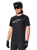 Alpinestars A-Dura Dri Oscar Jersey, MTB-shirt met korte mouwen, zwart met wit logo, vochtafvoerende technische stof, gedragen met een zwarte helm, zonnebril en handschoenen