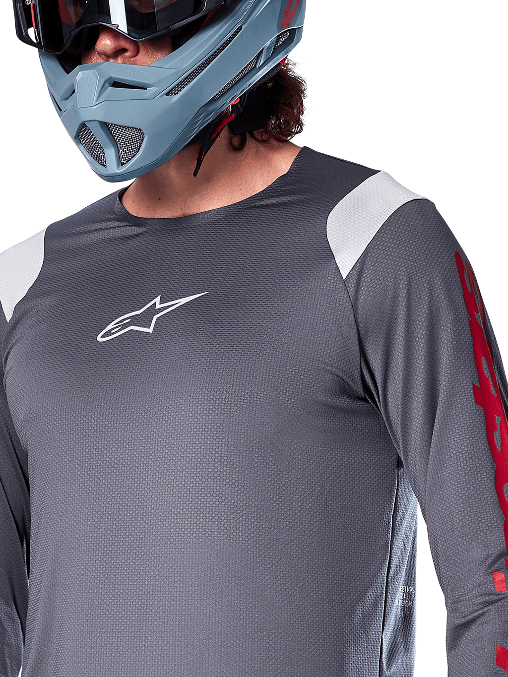 Alpinestars A-Supra Astar Long Sleeve Jersey, Dark Gray with white shoulder panels and red sleeve graphics, worn with a light blue-gray full-face helmet, performance mountain bike apparel