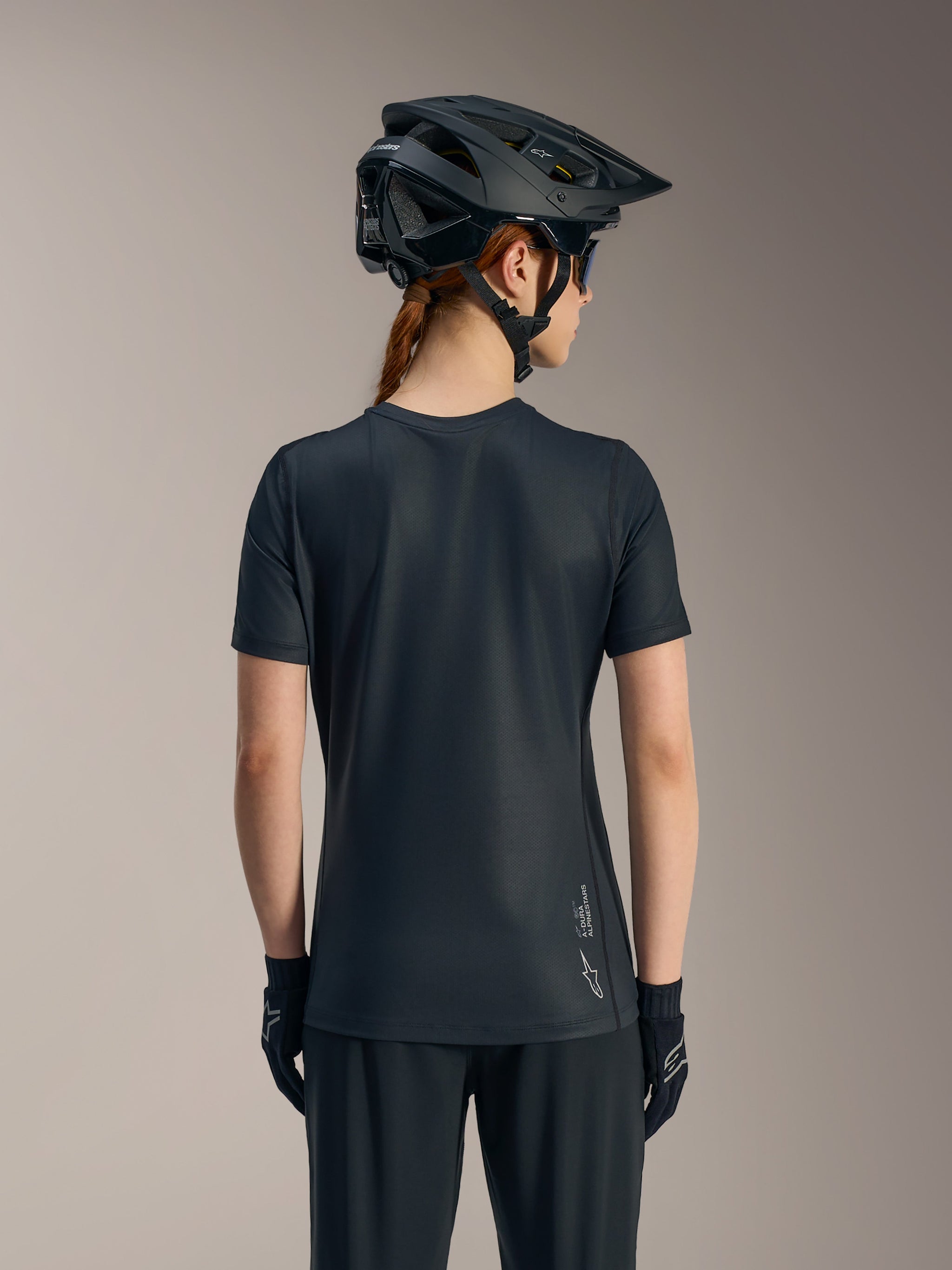 Zwarte Stella A-Dura Ride damesjersey met korte mouwen, achteraanzicht met verlengde achterkant en Alpinestars-logo.