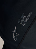 Detail van de zwarte Stella A-Dura Ride Jersey met wit Alpinestars-logo en A-DURA branding op jacquardstof.