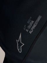 Detail van de zwarte Stella A-Dura Ride Jersey met wit Alpinestars-logo en A-DURA branding op jacquardstof.