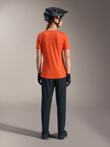 Alpinestars Stella A-Dura Ride fietsshirt voor dames in oranje, achteraanzicht met zwarte MTB-broek en helm.
