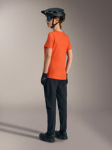 Oranje Alpinestars Stella A-Dura Ride jersey voor dames, achteraanzicht met zwarte MTB-broek en helm.