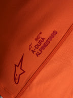 Orange Stella A-Dura Ride Jersey detail, featuring Alpinestars logo and A-DURA wordmark on technical stretch fabric.