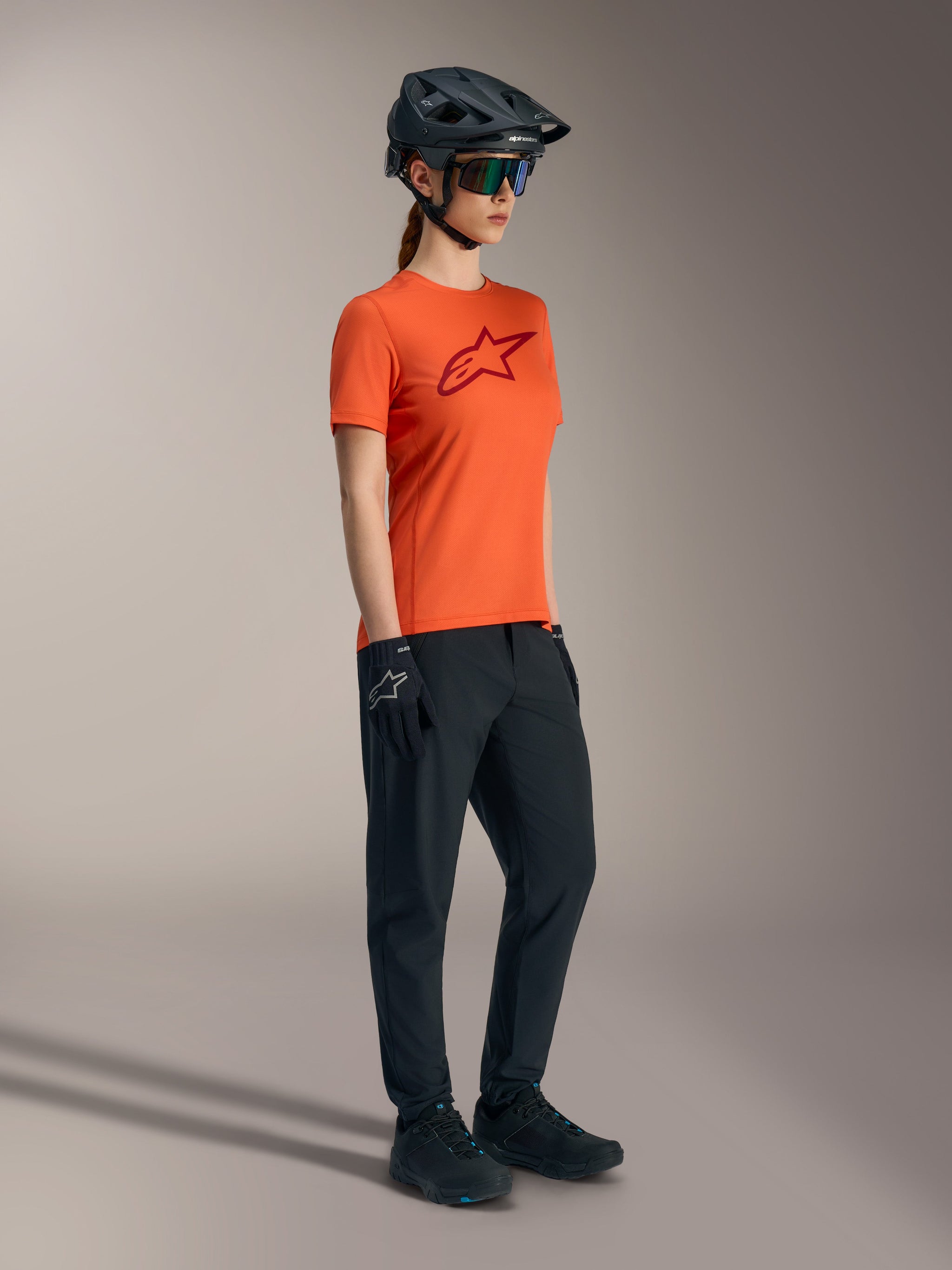 Oranje Stella A-Dura Ride jersey met rood borstlogo, technische dames MTB-kleding voor trailprestaties.
