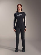 Alpinestars Stella A-Dura Dri Astar Jersey met lange mouwen, dames MTB-shirt, zwart met wit logo op de borst en lichtgekleurde mesh mouwpanelen, gecombineerd met een zwarte broek en zwarte schoenen, technische mountainbike-kleding