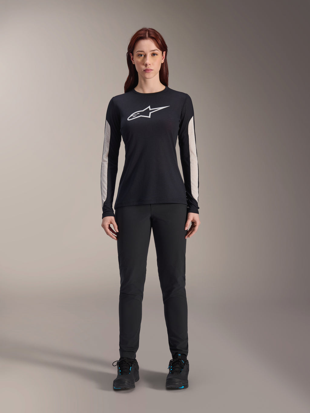 Alpinestars Stella A-Dura damesbroek, zwarte MTB-broek, met een specifieke damespasvorm en een gestroomlijnd ontwerp, gecombineerd met een zwart shirt met lange mouwen en zwarte fietsschoenen, duurzame uitrusting voor off-road mountainbiken