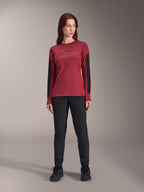 Alpinestars Stella A-Dura Dri Astar fietsshirt met lange mouwen voor dames in bordeauxrood, met een zwart Astars-logo op de borst en zwarte mesh-panelen op de mouwen, gestyled met een zwarte technische broek en sportschoenen, hoogwaardige mountainbikekleding voor dames.