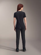 Alpinestars Stella A-Dura Dri Switch Jersey voor dames met korte mouwen, zwart, achteraanzicht op een model, voorzien van een verlengde achterkant en technische mesh-panelen, gecombineerd met een zwarte broek, performance MTB-wielerkleding
