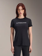 Alpinestars Stella A-Dura Dri Switch Jersey, MTB-shirt met korte mouwen voor dames, zwart met wit Alpinestars-logo op de borst, casual performance pasvorm, technische vochtafvoerende stof voor mountainbiken, vrouw met rood haar draagt het shirt