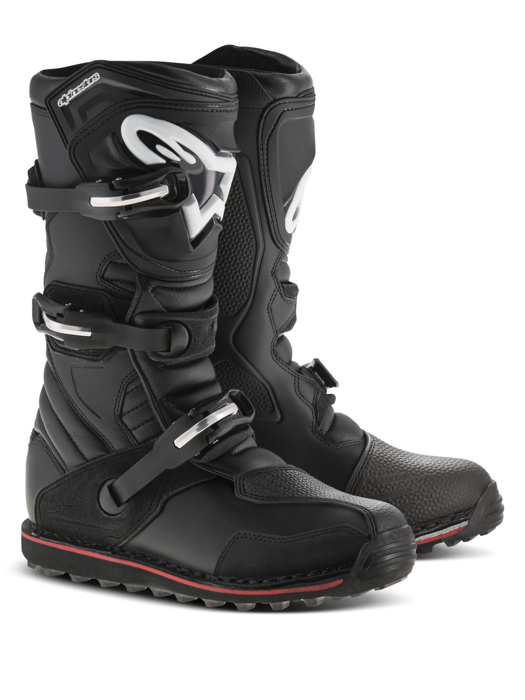 Alpinestars Tech-T laarzen, trial motorlaarzen, zwart met rode en witte accenten, voorzien van een sluitingssysteem met drie gespen, ergonomische scheenplaat met wit Astars-logo, dunne rode streep langs de zool, duurzame lederen constructie voor trial- en off-roadgebruik