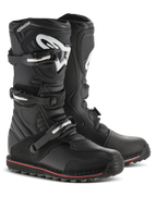 Alpinestars Tech-T laarzen, trial motorlaarzen, zwart met rode en witte accenten, voorzien van een sluitingssysteem met drie gespen, ergonomische scheenplaat met wit Astars-logo, dunne rode streep langs de zool, duurzame lederen constructie voor trial- en off-roadgebruik