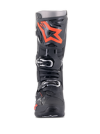 Alpinestars Tech 10 laarzen, motorcrosslaarzen, zwart en fluorood, vooraanzicht, met een groot fluorescerend rood sterlogo op de scheenplaat, zilveren gespen en een duurzaam zwart TPU-chassis.
