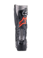 Alpinestars Tech 10 laarzen, motorcrosslaarzen, zwart en fluorood, achteraanzicht met technische TPU-schaal, donkergrijze panelen en een opvallend fluorood sterlogo op de kuit.