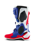 Alpinestars Limited Edition Fortitude Tech 10 Laars, motorcrosslaars, helder rood, wit en blauw, zijaanzicht met een multi-paneel TPU-chassis, zwarte beschermende honingraat-inzetstukken en Alpinestars-branding, professioneel off-road raceschoeisel