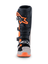Alpinestars 2026 Tech 7 Enduro laarzen, motorcross- en enduro-laarzen, zwart, warm grijs en fluo oranje, vooraanzicht met groot oranje sterlogo op het scheenbeen, sluitingssysteem met meerdere gespen en robuuste beschermingspanelen voor off-road prestaties.