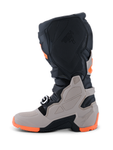 Alpinestars 2026 Tech 7 Enduro laarzen, motorcross- en enduro-laarzen, zwart, warm grijs en fluoriserend oranje, zijaanzicht met een robuuste dual-compound zool, TPU-bescherming op het scheenbeen en de enkel, en Tech 7-logo in reliëf.