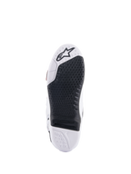 Alpinestars Tech 10 Supervented laarzen, wit en zwart zoolaanzicht, voorzien van een uitgebreid honingraat gripontwerp, zwarte vervangbare centrale insert, witte neus met Alpinestars sterlogo, geoptimaliseerd voor controle op de motorcross voetsteun.