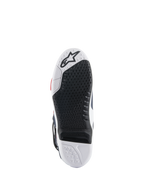 Alpinestars Tech 10 Supervented laarszool, onderaanzicht met een zwart-wit dual-compound ontwerp, honingraat gripstructuur, vervangbaar centraal inzetstuk en Alpinestars-logo in reliëf, geoptimaliseerd voor motorcross voetsteunprestaties.