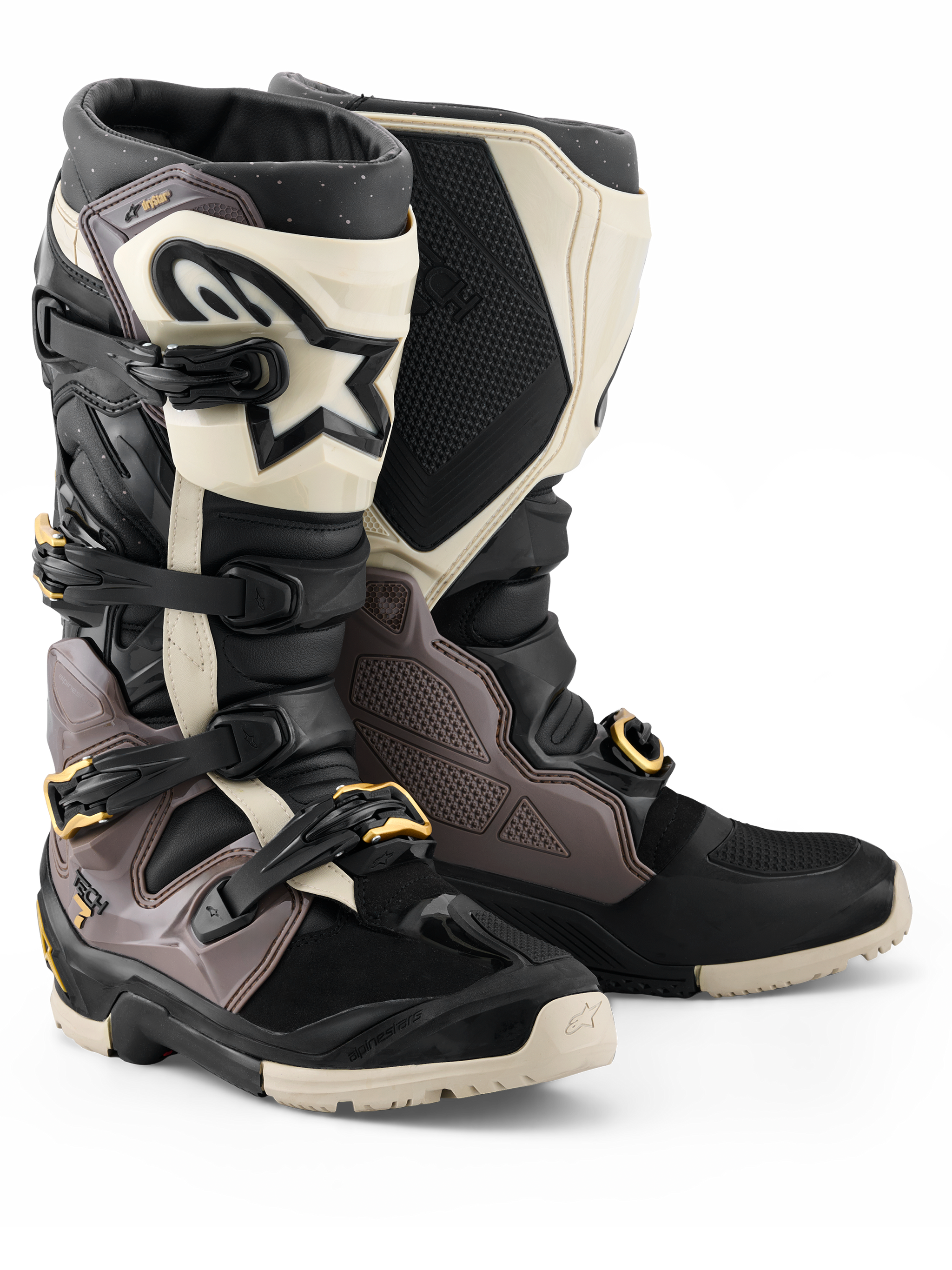 Alpinestars 2026 Tech 7 Enduro Drystar® laarzen, motorcross en enduro laarzen, zwart, donkergrijs en goud, voorzien van een robuuste TPU-schaal, snelontgrendelbare aluminium gespen met gouden accenten en een grote witte scheenplaat met een zwart logo, ontworpen voor off-road duurzaamheid.