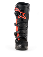 Alpinestars Tech 7 laarzen, motorcrosslaarzen, zwart en fluorood, vooraanzicht, met een groot fluorood Alpinestars sterlogo op de scheenplaat, een sluitsysteem met vier gespen en een duurzame TPU-constructie ontworpen voor off-road racing.