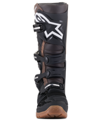 Alpinestars Tech 7 Enduro laarzen, motorcross- en enduro laarzen, zwart en donkerbruin, vooraanzicht met wit logo op de scheenplaat, verstelbaar gespsysteem en robuuste bruine compound zool voor off-road grip.