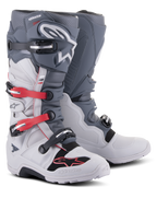 Alpinestars Tech 7 Enduro laarzen, off-road motorlaarzen, lichtgrijs en donkergrijs met felrode accenten, voorzien van een sluitingssysteem met meerdere gespen en een robuuste samengestelde zool ontworpen voor enduro- en trailritten.