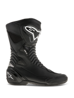 Alpinestars SMX S motorlaarzen, racinglaarzen voor motorrijders, zwart met witte logo's, zijaanzicht met duurzame microvezelconstructie, versterkte scheenbeen- en hielbescherming, flexibele accordeon-stretchzones, gestroomlijnd aerodynamisch ontwerp voor sportief rijden
