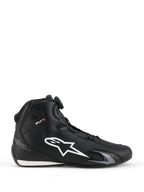 Alpinestars Celer Schoenen, motorschoenen, zwart en wit, lateraal zijprofiel met groot wit sterlogo, draaiknop van het Rotor-sluitingssysteem voor pasvormaanpassing, en een strak sportief silhouet