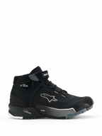 Alpinestars CR-X Women's Drystar motorrijschoenen, zwarte hoge motorsneakers voor dames, zijaanzicht van urban rijschoeisel met vetersluiting en klittenband enkelband, wit Alpinestars sterlogo, 'Drystar' en 'TPF' branding op de tussenzool, robuuste rubberen zool met witte en grijze patronen.