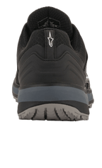 Alpinestars Meta Trail schoenen, performance hardloopschoenen, zwart en donkergrijs, achteraanzicht met hiellus en wit Astar-logo, donkergrijze tussenzool en buitenzool met textuur, casual motorsport-geïnspireerde schoenen voor de paddock