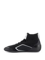 Alpinestars Supertech schoenen, autosport schoenen, zwart, zijaanzicht met een gebreid bovenwerk, carbon hielkap en witte geometrische accenten, professioneel motorsport schoeisel