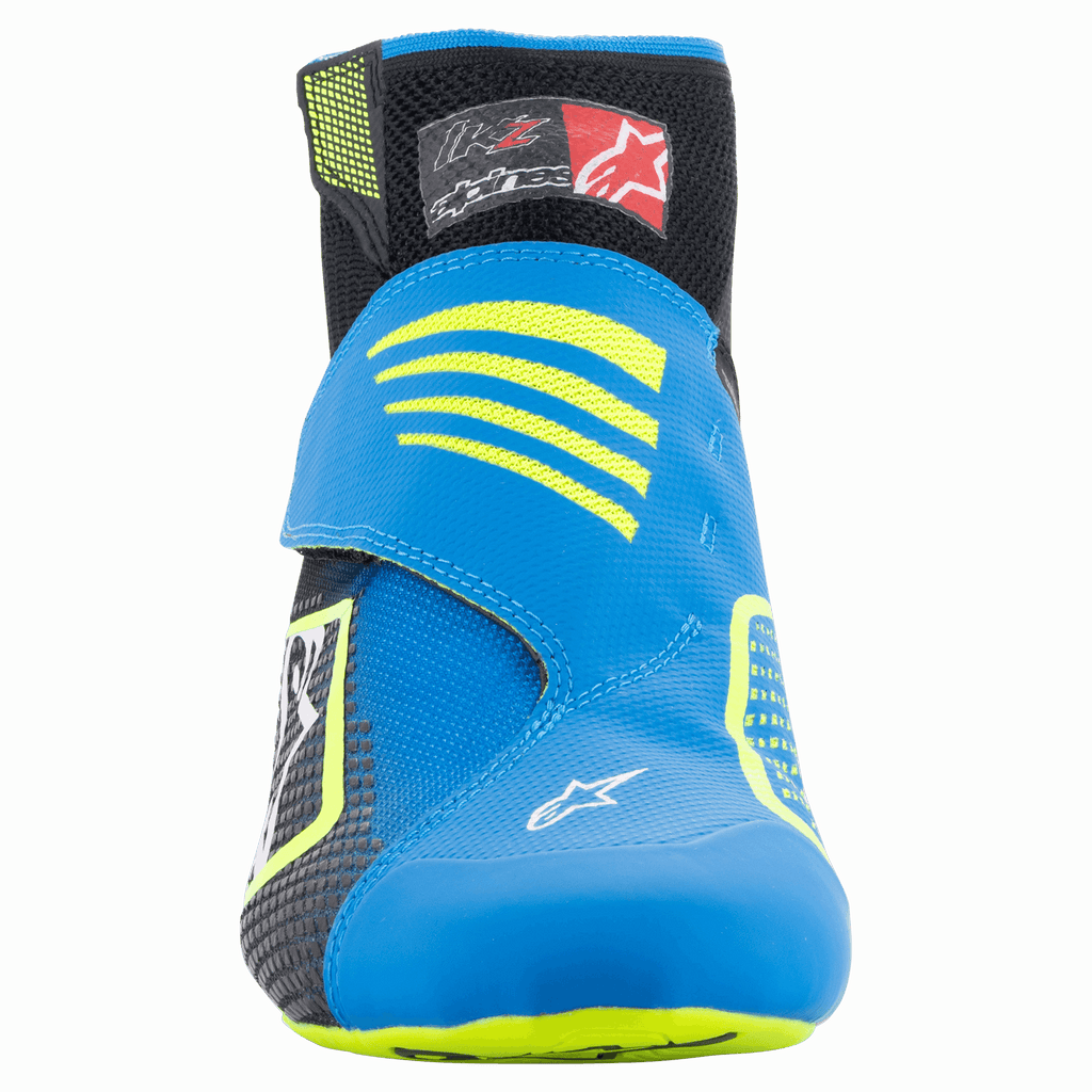Alpinestars Tech-1 KZ V2 schoenen, karting schoenen, Black Enamel Blue en Yellow Fluo, vooraanzicht met het naadloze gebreide bovenwerk, opvallende blauwe band met gele accenten en zwarte enkelkraag.