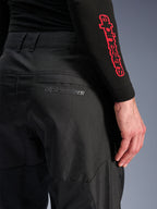 Alpinestars C-1 Air Broek, zwarte textiele motorbroek, close-up van de achterzak met een subtiel grijs Alpinestars-logo, voorzien van ademende mesh-panelen en duurzame polystof, ontworpen voor stedelijk rijcomfort