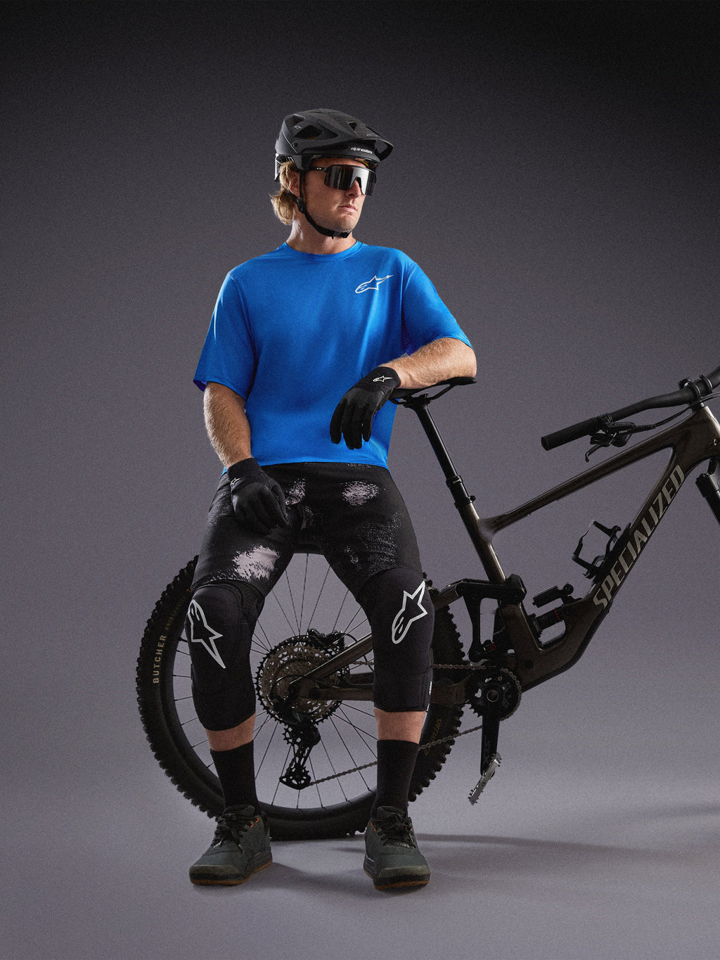 Blauwe Alpinestars A-Dura Air SS Jersey en Black Camo Ride Shorts gedragen door mountainbiker in studio.