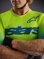 Alpinestars A-Dura ASTARS Jersey 2.0 in Yellow Fluo, korte mouwen MTB-top met blauwe graphics en technische stretchstof.