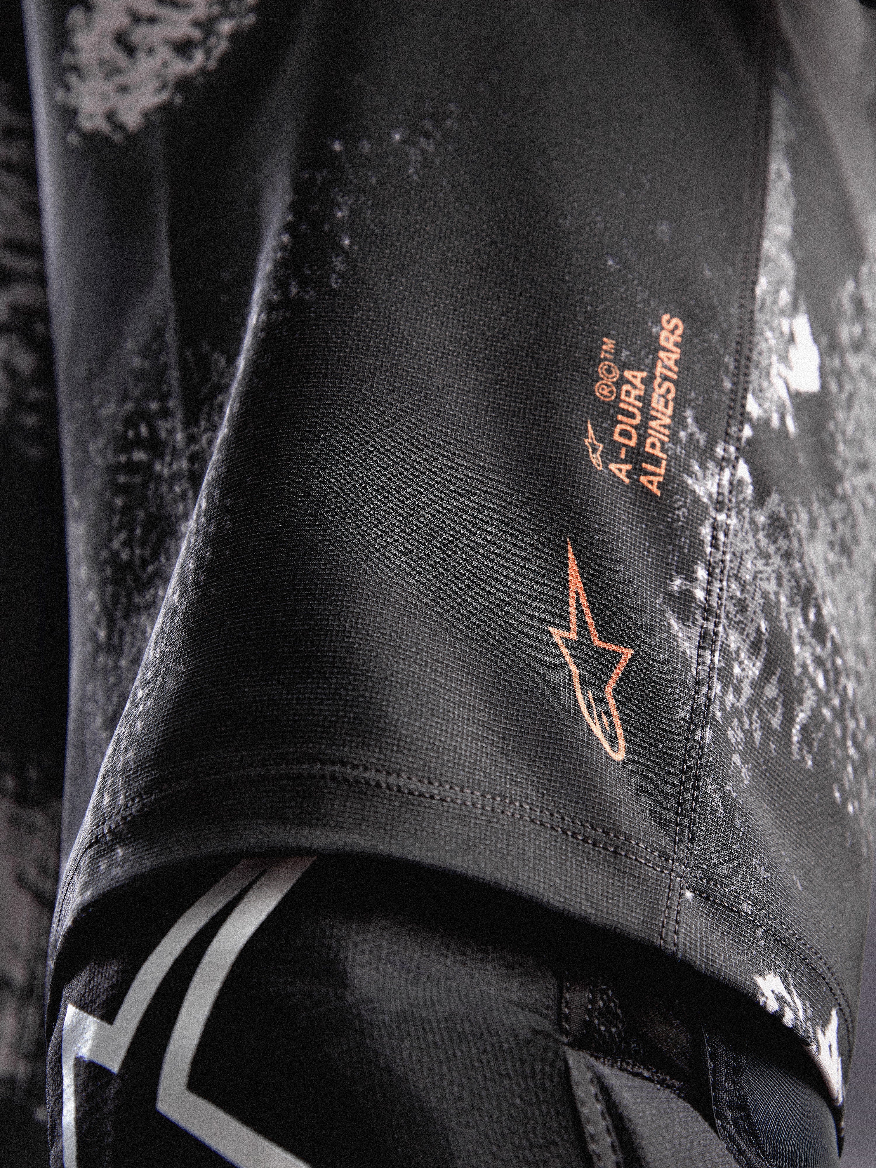 A-Dura Ride shorts in Black Camo met oranje Alpinestars-logo op duurzame 4-way stretch geweven stof voor MTB.